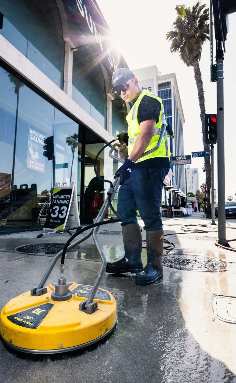 a man in a yellow vest is cleaning the floor